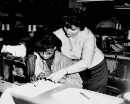 One woman teaches another to sew in a factory, October 21, 1966.