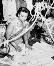 A woman arranging clothing to press
