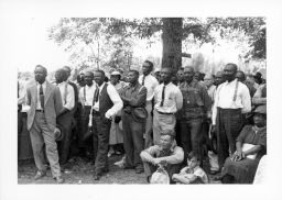 Black and White STFU members including Olin Lawrence, seated in front, listen to Norman Thomas speak outside Parkin, Arkansas on September 12, 1937.
