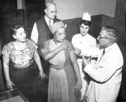 ILGWU Local 105 members receiving flu shots, includes Dr. Louie Pincuss (?), nurse Margret Shanham, Adia Petrin, Nick Petrin, and Olivia Mayaris, December 12, 1957