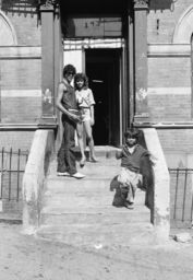 Man, woman, and boy on building stoop
