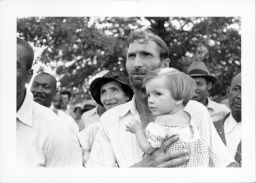 Men, women and children, Black and White, listen to a speaker at an outdoor Southern Tenant Farmers Union meeting