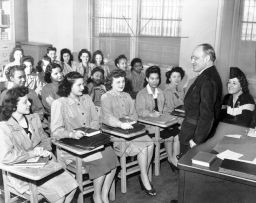 Principal Mortimer C. Ritter addresses an academic class at the Needle Trades High School, New York, in April 6, 1944.  Students include Fergel Levine, Jean Cultrera, and Ellen Perino.