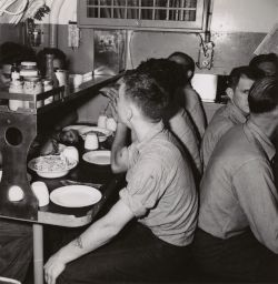 Soldiers eating in mess hall on submarine.