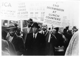 Picketers, including Charles Zimmerman, carry signs such as "End Discrimination at Lunch Counters"