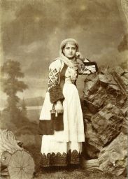 [Woman in traditional Greek clothing]