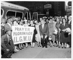 Prayer pilgrimage attendees holding an ILGWU sign in front of their bus