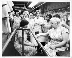 Garment workers at the Abe Schrader Shop listen to funeral services for Dr. Martin Luther King, Jr., on a portable radio, April 9, 1968.