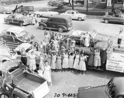 Women from the ILGWU Upper South Department waving from among decorated cars with placards.