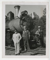 Dr. Paul S. Hill, C. Grattan Price Jr., and Wade W. Menefee Jr. standing beside Tweetsie locomotive on the day of the Golden Spike Ceremony