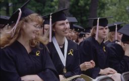 Three women graduates smile during Commencement