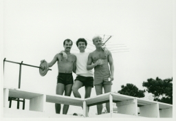 Smiling men with barbells on Fire Island trip