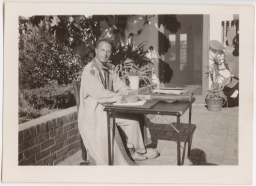 Clarence S. Stein working in tropical courtyard