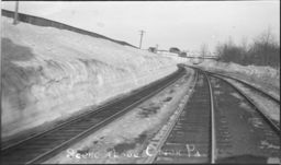 Train tracks by large snow drifts