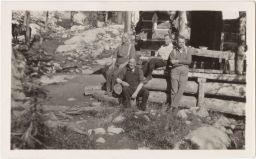 Men sitting on log porch