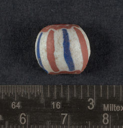 White drawn glass bead with red core and and red and navy stripes