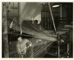 Close-up view of man at warping machine, Cyril Johnson Woolen Company, Stafford Springs, Connecticut