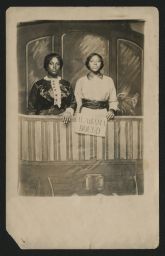 Two women standing with a sign that reads "Alabama Bound"