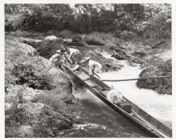 Four people pulling boat upriver, Sarawak, Malaysia