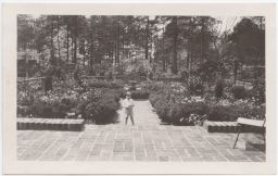 Ralph Hanes estate, child standing in center of courtyard and garden