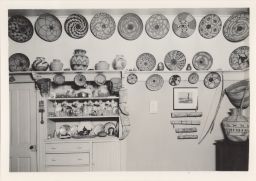 Photograph of Native American baskets displayed above a china cabinet.