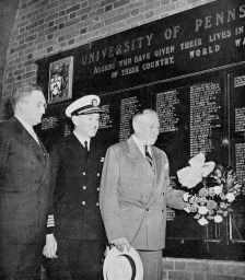 Thomas Sovereign Gates (Penn President, 1930-1944) places a wreath at base of War Memorial plaque in Furness Library portico, part of 1945 Alumni Day ceremonies