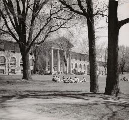 View of Goldwin Smith Hall with class seated on the lawn in front, ca. 1950's