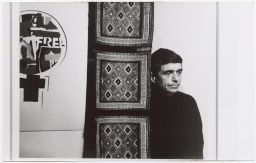 Daniel Berrigan looking pensive next to artwork