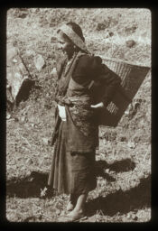 mahila tamang bhushama doko bokdai (महिला तामाङ भुषामा  डोको बोक्दै / A Tamang Dressed Woman Carrying a Basket (Doko))