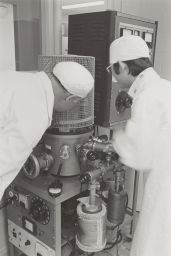 NRRFSS (National Research and Resource Facility for Submission Structures), two unidentified researchers in lab coats and hats at apparatus, 1975?