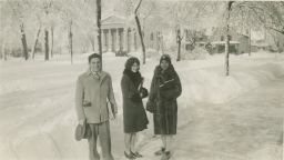 Three students with books outside in winter