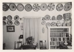Photograph of Native American baskets displayed above a window and bookshelf.