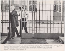Philip Berrigan entering prison gates followed by an officer