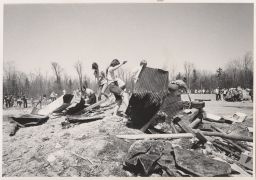 Female participants clamber in a pile of lumber and metal.