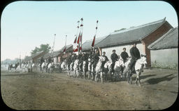 A large procession of Japanese troops on horseback, some with flags