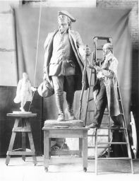 R. Tait (Robert Tait) McKenzie (1867-1938) at work in his studio on his sculpture of young Benjamin Franklin