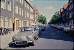 Parked cars, housing, and the roadbed down the Leimudenstraat (Amsterdam, NL)