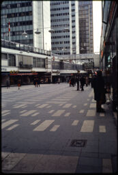 Pedestrian shopping street with three high-rises in the distance (Hötorget, Stockholm, SE)