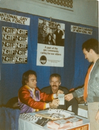 Three men at a National Gay Task Force booth