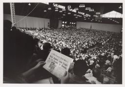 Person reading Daily Sun in the audience at Barton Hall.
