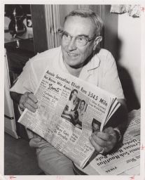 Photograph of John Paul Jones holding newspaper.