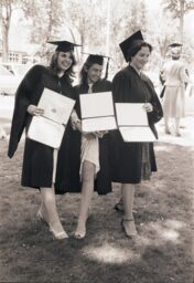 Three women display their degrees