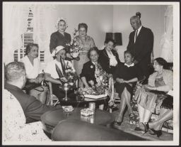 Group portrait of men and women in living room