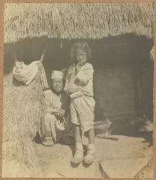 [Korean farmer and daughter under thatched roof]