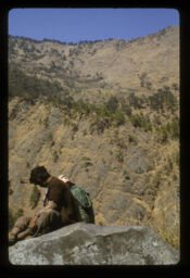 manisharu dhungama basera aram gardai (मानिसहरु ढुंगामा बसेर आराम गर्दै / Man Taking a Rest and Sitting on a Rock)