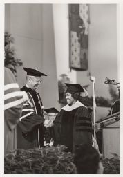Pres. James Perkins congratulating a PhD recipient at Commencement