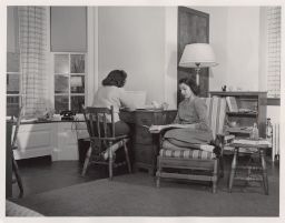 Photograph of two female students in a Clara Dickson Hall dorm room.