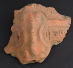 Body sherd of a modelled, red slipped vessel excised for negative effect with hollow reptilian antique