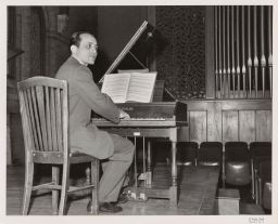 William W. Austin Prof. of Musicology at a piano (harpsicord?) delivering a lecture