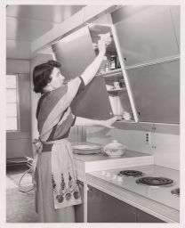 Barbara Kenrick, easily reaches for dishes